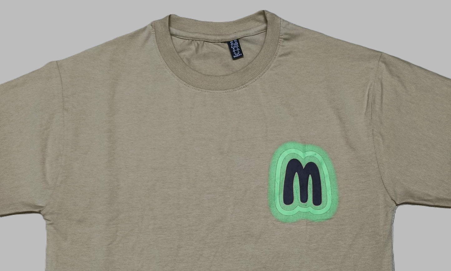 Men’s Beige Graphic T-Shirt with Neon Green “M” Logo – Urban Casual Streetwear